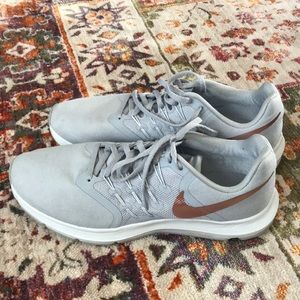 Gray Nike run swift with gold swoosh.